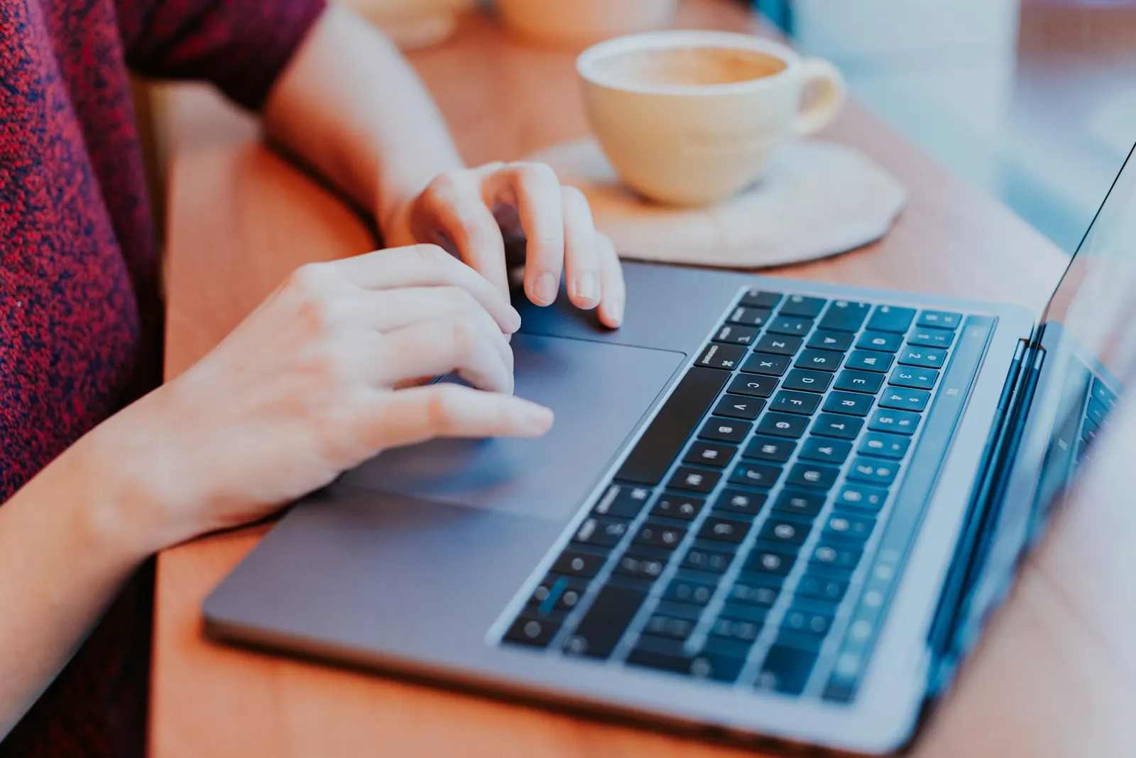 Human hands hovering over a keyboard