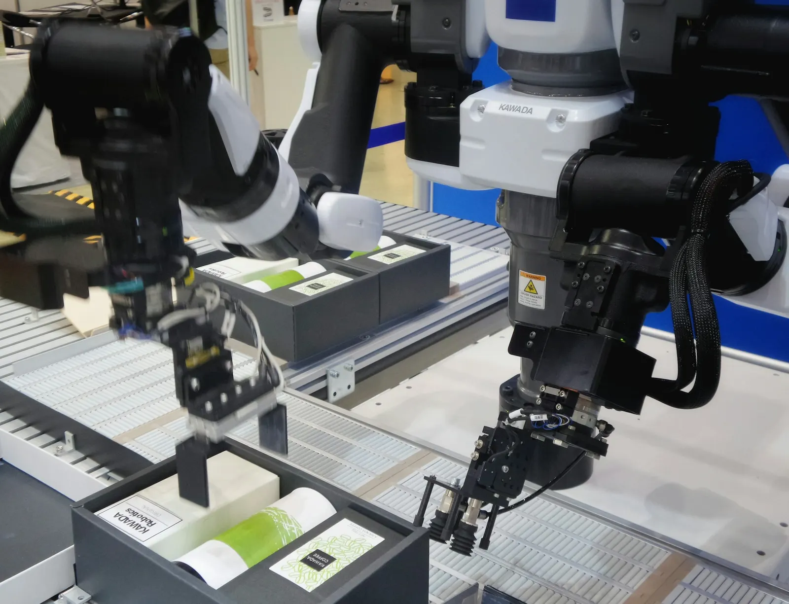 Robotic arms packing three different items into one box to make a uniform assortment package for a brand